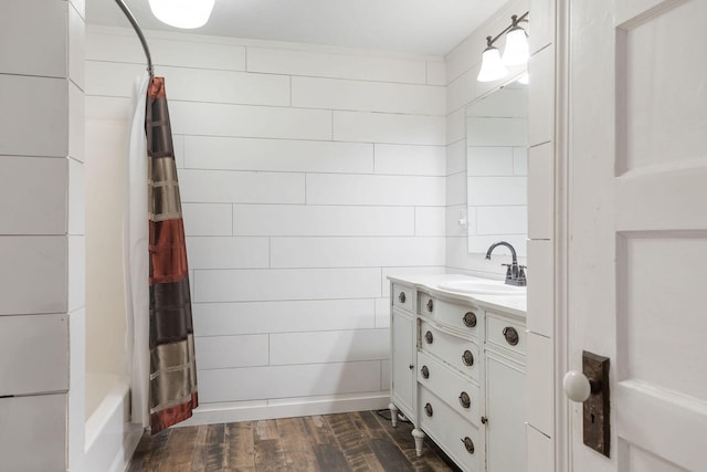 bathroom featuring wood walls, shower / bath combo with shower curtain, wood-type flooring, and vanity