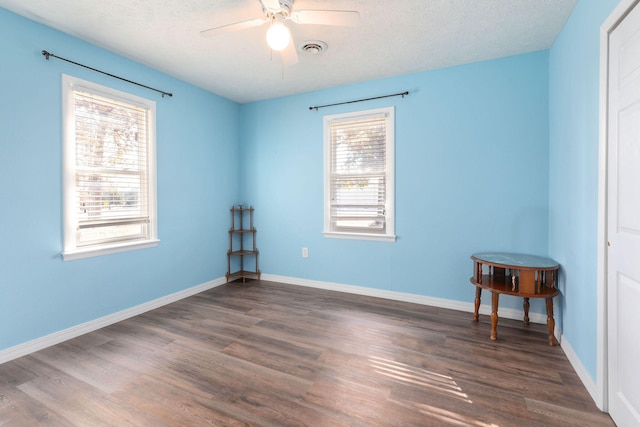 spare room with dark wood-type flooring, a textured ceiling, and ceiling fan