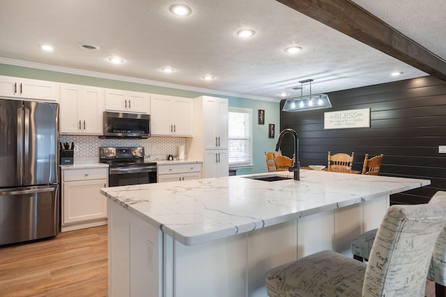 kitchen featuring hanging light fixtures, white cabinetry, and appliances with stainless steel finishes