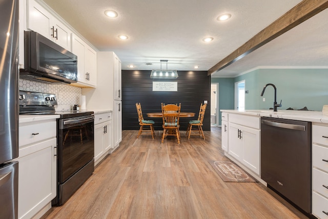 kitchen with pendant lighting, white cabinetry, and appliances with stainless steel finishes