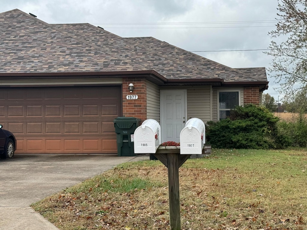 single story home with a garage and a front lawn