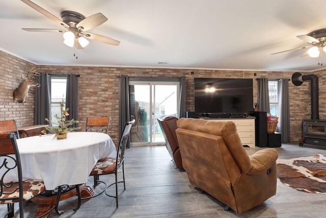 218 Windridge Rd, Branson, MO 65616 - dining space featuring ceiling fan, a wood stove, brick wall, plenty of natural light, and crown molding