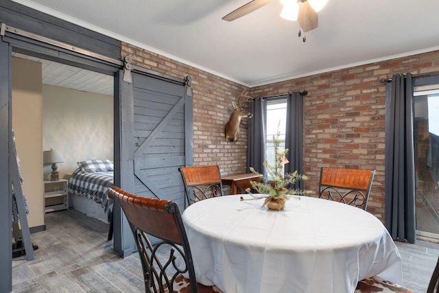 218 Windridge Rd, Branson, MO 65616 - dining room featuring a ceiling fan, brick wall, wood finished floors, a barn door, and crown molding