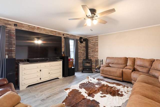 218 Windridge Rd, Branson, MO 65616 - living area with a wood stove, a ceiling fan, light wood-style flooring, ornamental molding, and brick wall