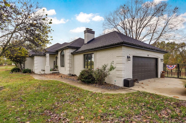 view of side of home featuring a garage and a yard