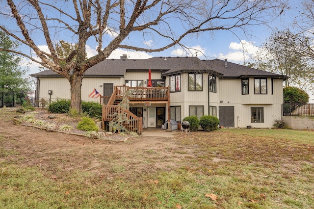 rear view of property with a wooden deck, a lawn, and a patio