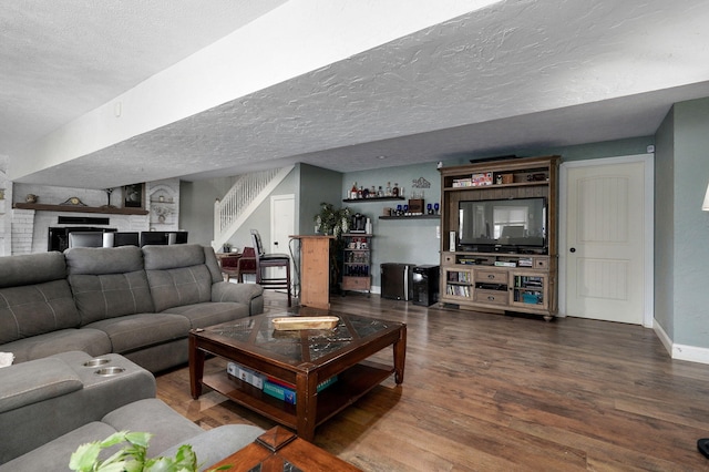 living room with bar, a textured ceiling, and hardwood / wood-style flooring