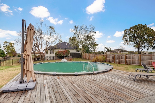 view of swimming pool featuring a wooden deck and a lawn