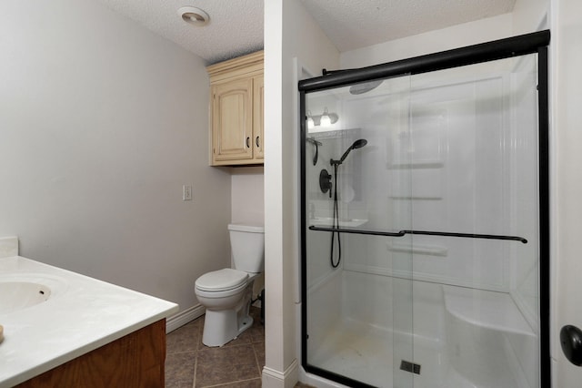 bathroom with tile patterned floors, toilet, a textured ceiling, vanity, and a shower with shower door