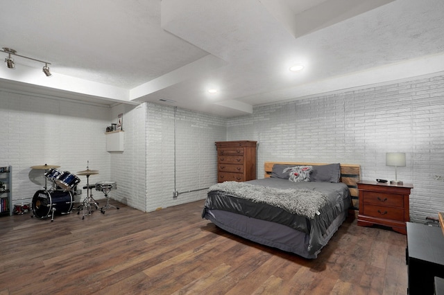 bedroom featuring dark hardwood / wood-style floors and brick wall