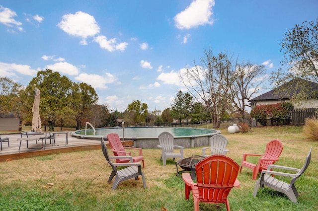 view of yard with an outdoor fire pit and a pool side deck