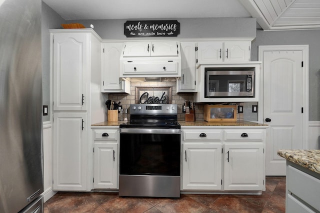 kitchen with range hood, appliances with stainless steel finishes, light stone counters, and white cabinets