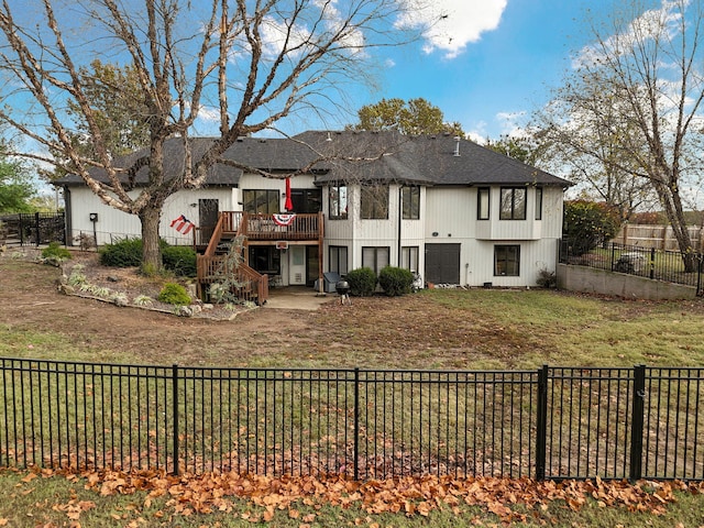 rear view of house featuring a patio, a wooden deck, and a yard