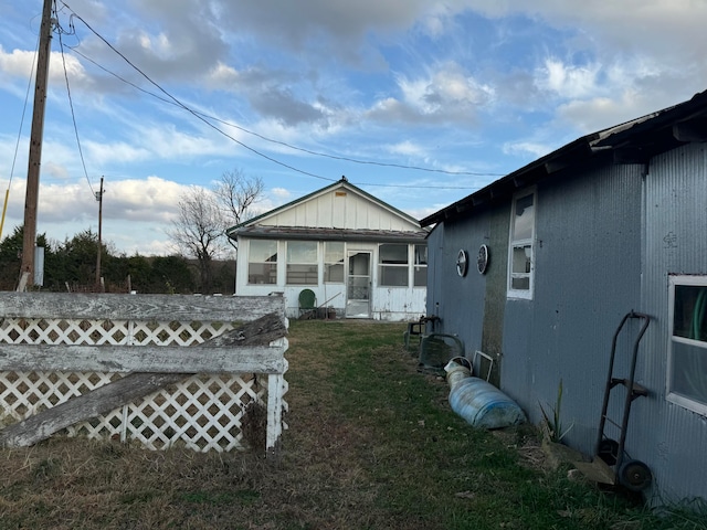 view of side of home with a lawn and a sunroom