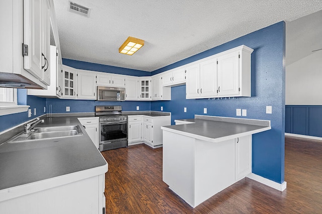 kitchen featuring dark wood-type flooring, white cabinets, sink, a textured ceiling, and appliances with stainless steel finishes