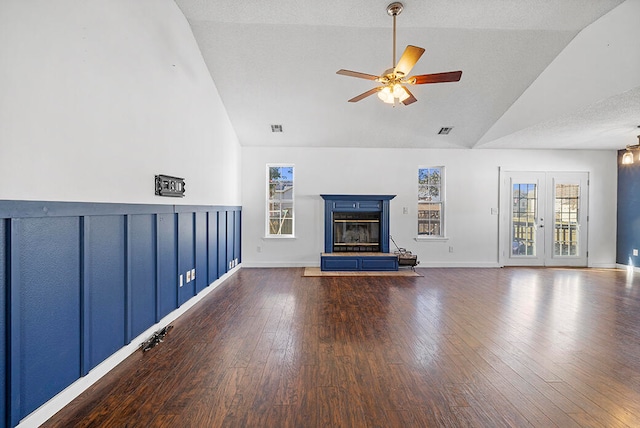 unfurnished living room with dark wood-type flooring, a wealth of natural light, and a tile fireplace