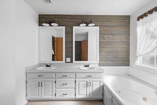 bathroom featuring wooden walls, a healthy amount of sunlight, and a textured ceiling