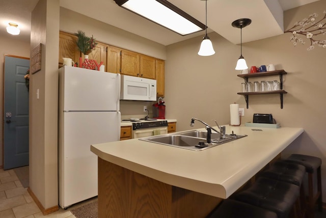 kitchen featuring white appliances, a kitchen bar, pendant lighting, sink, and kitchen peninsula