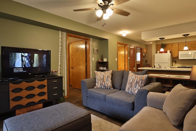 living room featuring dark wood-type flooring and ceiling fan