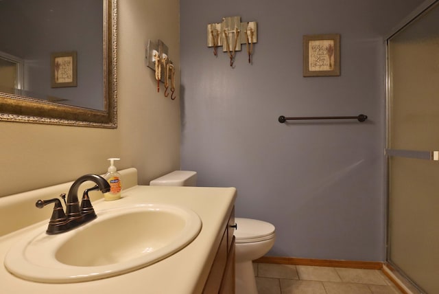 bathroom featuring tile patterned flooring, vanity, toilet, and a shower with shower door