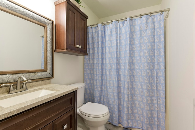 bathroom with curtained shower, vanity, and toilet