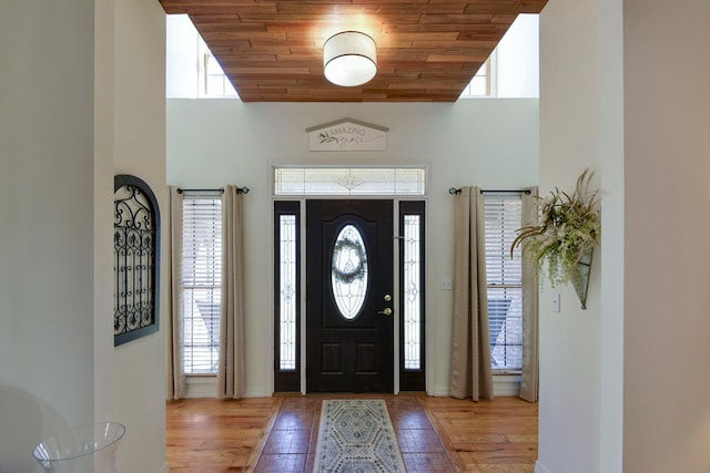 foyer with light hardwood / wood-style floors, wood ceiling, and a healthy amount of sunlight