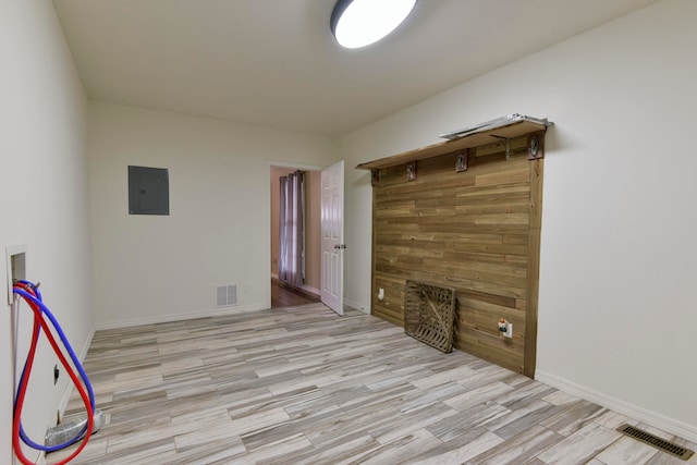 interior space featuring electric panel and light wood-type flooring