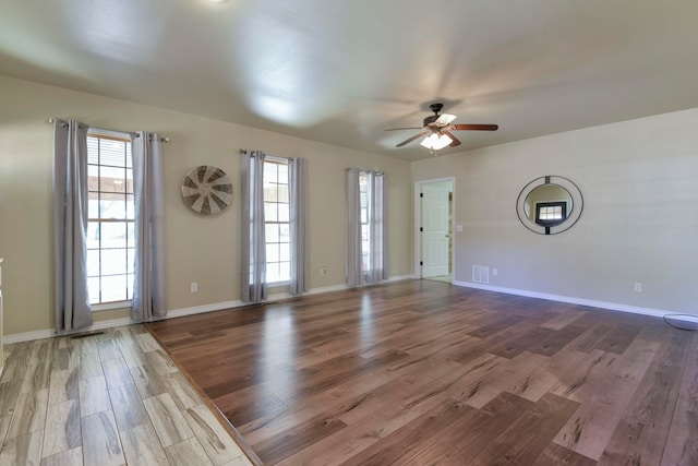 spare room featuring a wealth of natural light, wood-type flooring, and ceiling fan