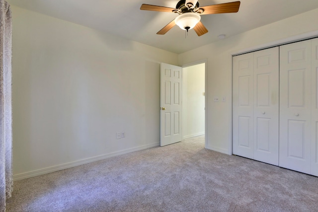 unfurnished bedroom featuring ceiling fan, a closet, and light colored carpet