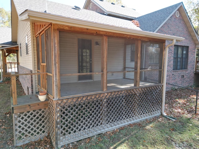 back of property featuring a deck and a sunroom