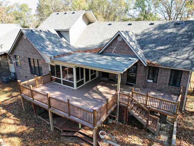 rear view of house with a sunroom, central AC unit, and a wooden deck