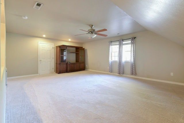 interior space featuring lofted ceiling, light colored carpet, and ceiling fan