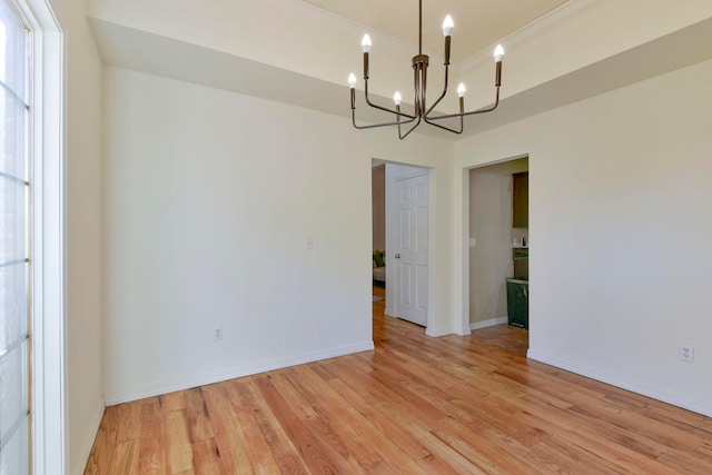 unfurnished room with light wood-type flooring and an inviting chandelier