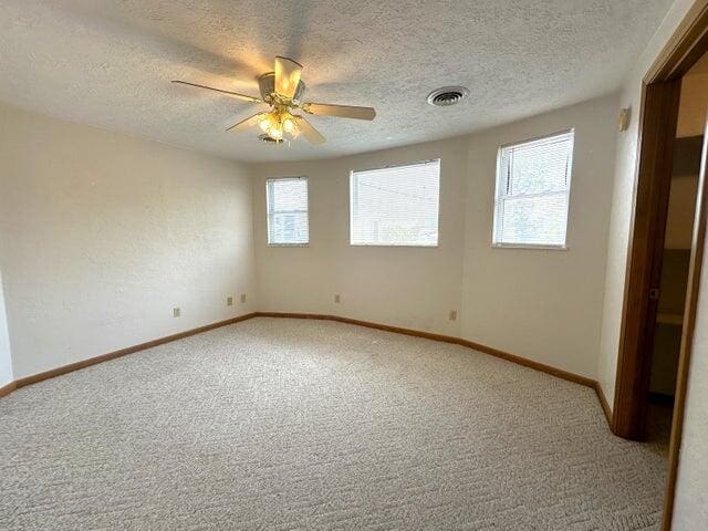 unfurnished room with carpet floors, a textured ceiling, and ceiling fan