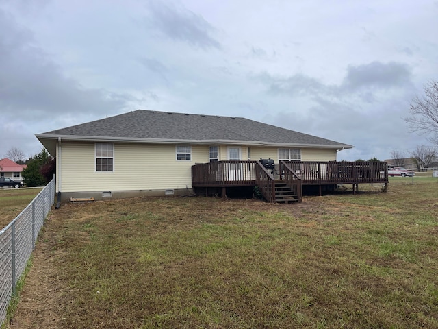 rear view of house with a deck and a yard