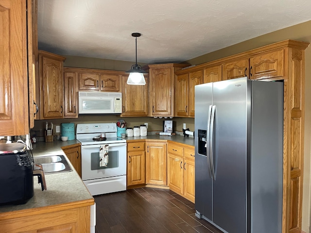 kitchen featuring dark wood-type flooring, a textured ceiling, sink, pendant lighting, and white appliances