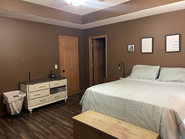 bedroom with dark hardwood / wood-style flooring and ceiling fan