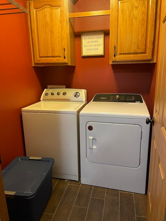 washroom with cabinets, dark hardwood / wood-style flooring, and washer and clothes dryer