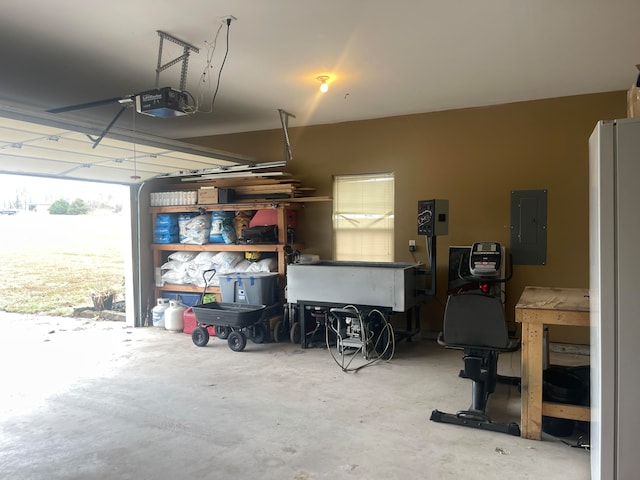 garage with electric panel, white fridge, and a garage door opener