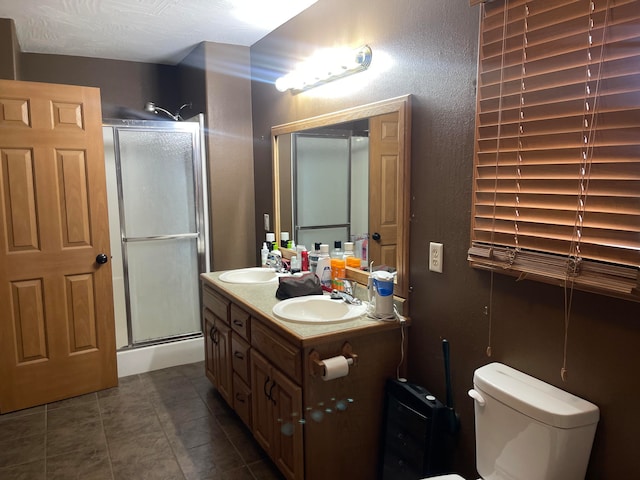 bathroom with tile patterned flooring, vanity, toilet, and a shower with shower door