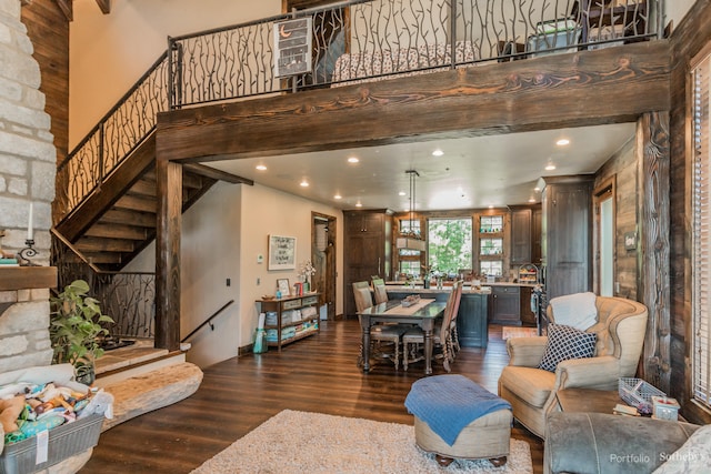 living room featuring a towering ceiling and dark hardwood / wood-style floors