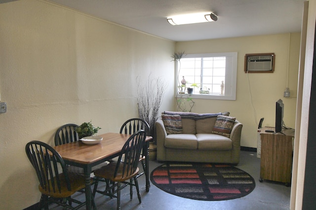 dining area featuring a wall unit AC and concrete flooring