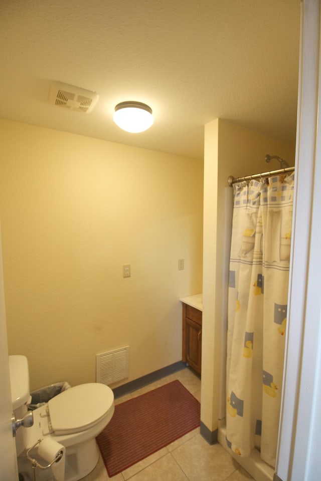 bathroom with toilet, a shower with curtain, vanity, and tile patterned floors