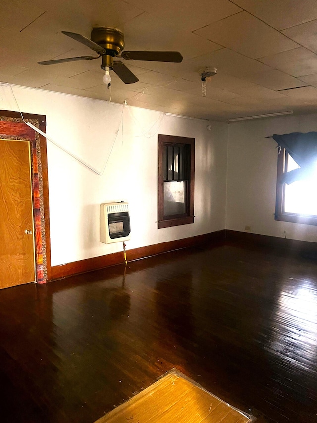 empty room featuring heating unit, hardwood / wood-style flooring, and ceiling fan