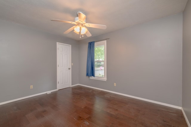 spare room featuring dark wood-type flooring, a textured ceiling, and ceiling fan