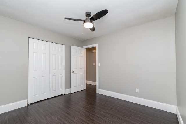 unfurnished bedroom with dark hardwood / wood-style flooring, ceiling fan, and a closet