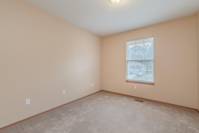 spare room featuring light colored carpet