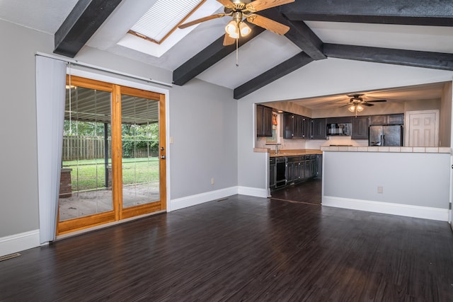 unfurnished living room with vaulted ceiling with skylight, sink, ceiling fan, and dark hardwood / wood-style floors