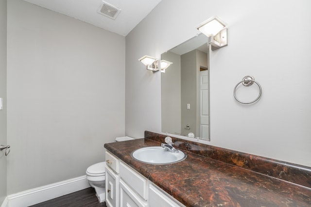 bathroom with hardwood / wood-style flooring, vanity, and toilet