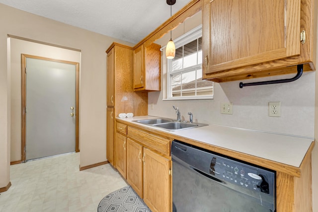 kitchen featuring pendant lighting, a textured ceiling, stainless steel dishwasher, and sink